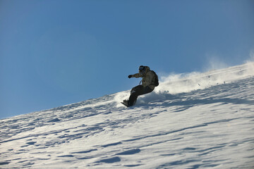 freestyle snowboarder jump and ride free style  at sunny winter day on mountain