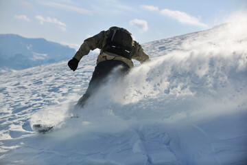 freestyle snowboarder jump and ride free style  at sunny winter day on mountain
