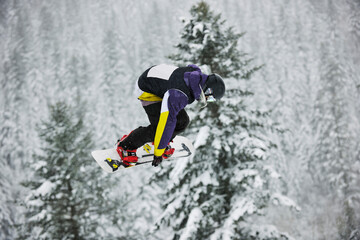 Fototapeta na wymiar young boys jumping in air ind showing trick with snowboard at winter season