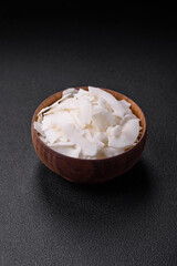 White dry coconut flakes in a wooden bowl prepared for making desserts