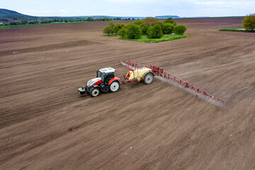 Aerial view of field and tractor spraying grain