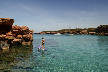 Fototapeta na wymiar Unleash Your Inner Adventurer Conquer Ibiza's Waves with Paddle Surfing