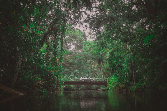 Car or SUV crossing the bridge over river in jungle environment in Costa Rica. Exploration with a car, epic roadtrip, adventurous backdrop for a car trip. Next stop - adventure.