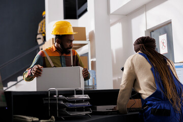 Shipment manager waiting for parcel electronic invoice at reception desk. African american...