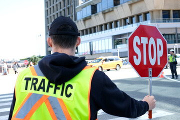 A construction road worker stopping traffic, holding a stop sign. canada Vancouver 2023