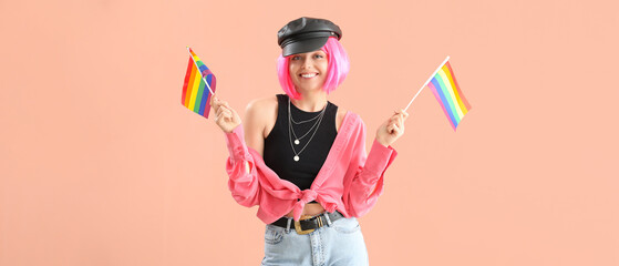 Beautiful young woman with LGBT flags on beige background