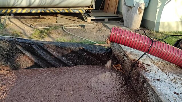 Pomace produced in the extraction of olive oil coming out through a hose towards a deposit. Full HD video.