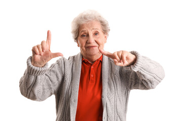 Senior woman showing loser gesture on white background