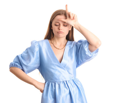 Sad young woman in dress showing loser gesture on white background