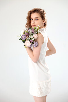 young girl in a white dress on a white background with flowers