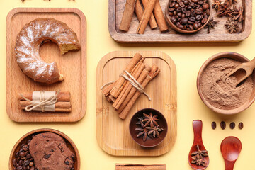 Composition with cinnamon sticks, powder, coffee beans, cake and cookies on yellow background