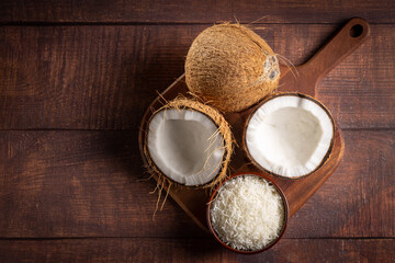 Obraz na płótnie Canvas Whole coconut, pieces of coconut and shredded coconut on the table.