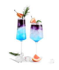 Glasses of gin and tonic with grapefruit and rosemary on white background