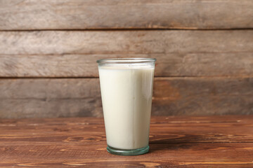 Glass of fresh milk on wooden background