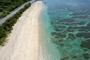 沖縄本島国頭郡国頭村謝敷のビーチをドローンで空撮する風景 Aerial drone...