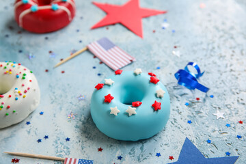Obraz premium Composition with donuts, USA flags and confetti on blue grunge table. Independence Day celebration