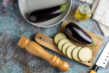 Sliced eggplant on the cutting board on the table.