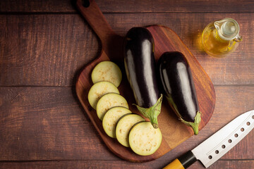 Sliced eggplant on the cutting board on the table.
