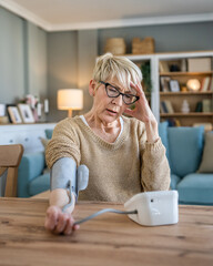 Senior caucasian woman check blood pressure measure device on hand - obrazy, fototapety, plakaty