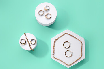 Decorative podiums with beautiful jewellery on turquoise background