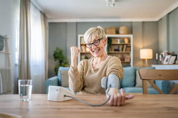 Senior caucasian woman check blood pressure measure device on hand