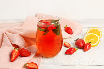 Glass of tasty strawberry juice on white table