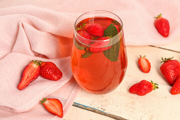Glass of tasty strawberry juice on white table