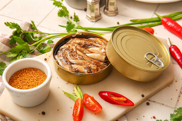 Board of canned smoked sprats with parsley and chilli on white tile background