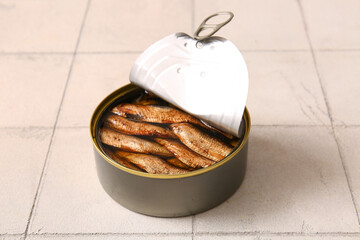 Canned smoked sprats on white tile background