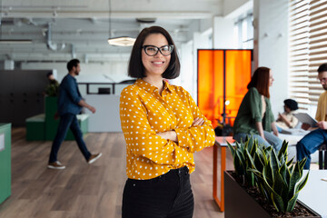 Portrait of smiling businesswoman,  confident CEO holding arms crossed wearing stylish eyeglasses...