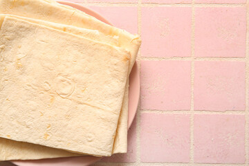 Plate with fresh lavash on pink tile background
