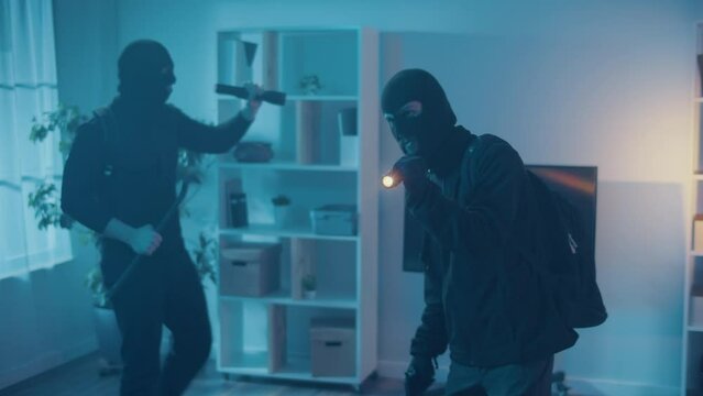 Two Robber in Black Mask Broke Into an Apartment or House. A Criminals in the Night with a Flashlight, Gun and Crowbar Looking for Jewelry and Money.High-Definition Cameras.Hidden Surveillance Cameras