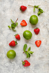 Fresh strawberries with lime and mint on grey background