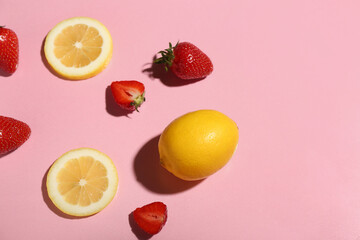 Fresh strawberries and lemons on pink background