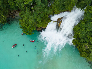 An amazing waterfall tumbles out of rainforest and into the ocean on the coast of West Papua,...