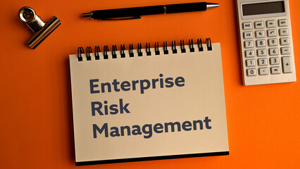 There is notebook with the word Enterprise Risk Management.It is as an eye-catching image.