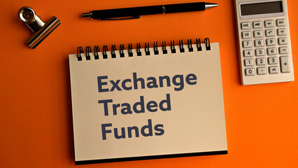 There is notebook with the word Exchange Traded Funds.It is as an eye-catching image.