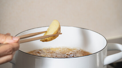 フライドポテト(くし切り)を揚げる　調理シーン