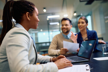 African American insurance agent having meeting with her clients in office.