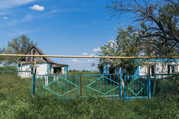 Obraz na płótnie Canvas Countryside. The fence of a house destroyed by artillery shelling. War in Ukraine