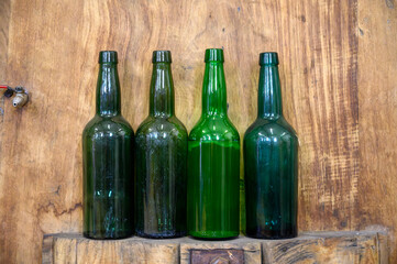 Bottles for traditional natural Asturian cider made from fermented apples in barrels for several...