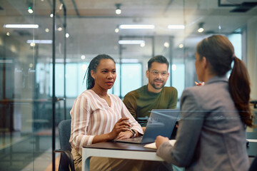 Black female CEO talking with colleagues during meeting in office.
