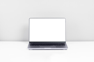 Laptop or desktop computer with a blank white screen and space for your inscription, graphic or logo standing on a white desk or table, on a light white background
