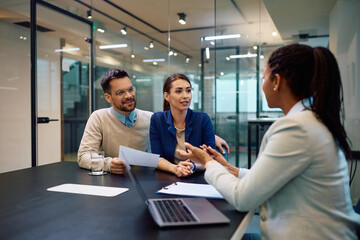 Young couple having consultations with insurance agent in office.