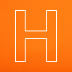 Letter H uppercase written in white color isolated on orange foamy background