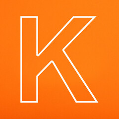 White letter K uppercase on orange foamy background