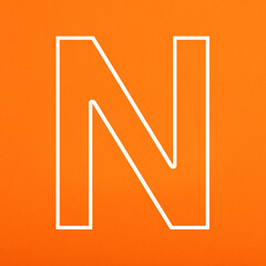 Letter N uppercase written in white color isolated on orange foamy background