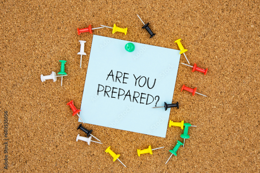 Poster are you prepared text on light blue post-it paper pinned on bulletin cork board surrounding by multi
