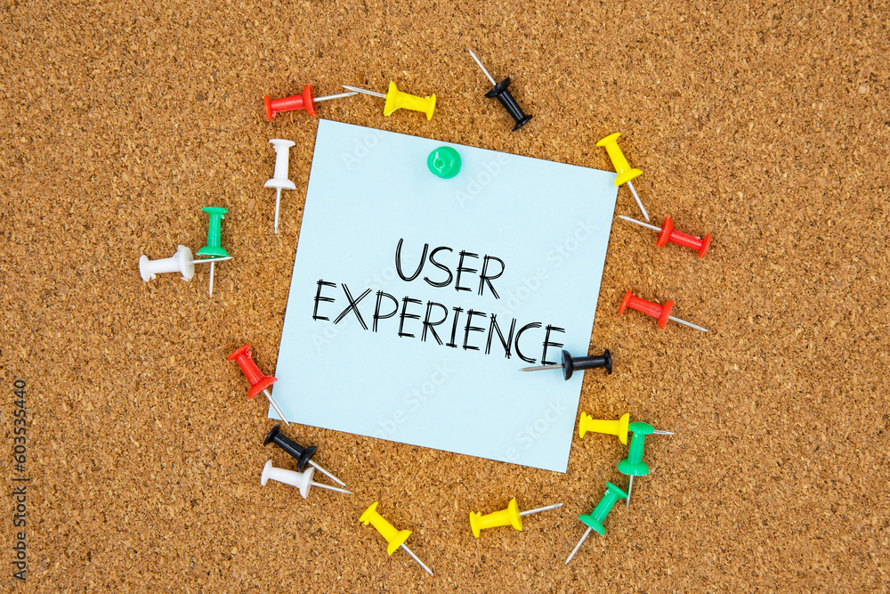Poster user experience text on light blue post-it paper pinned on bulletin cork board surrounding by multi 