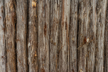 Old wooden log fence with rough grain texture